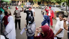 Petugas kepolisian berpakaian pejuang jaman dulu saat memberikan pengarahan kepada warga yang akan ikut vaksin Covid-19 di Polsek Pasar Rebo, Jakarta, Selasa (17/8/2021). Para petugas berkostum pejuang jaman dulu memeriahkan HUT ke-76 Republik Indonesia. (Liputan6.com/Angga Yuniar)