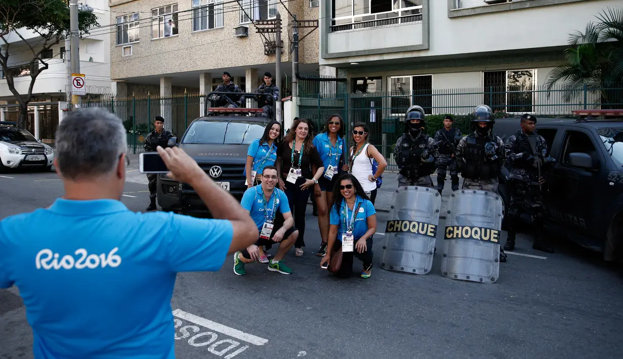 Sejumlah relawan berfoto bersama pasukan keamanan Brasil di luar stadion Maracana menjelang upacara pembukaan pesta olahraga terakbar Olimpiade 2016 di Rio de Janeiro, 5 Agustus 2016. (AFP PHOTO/Adrian Dennis)