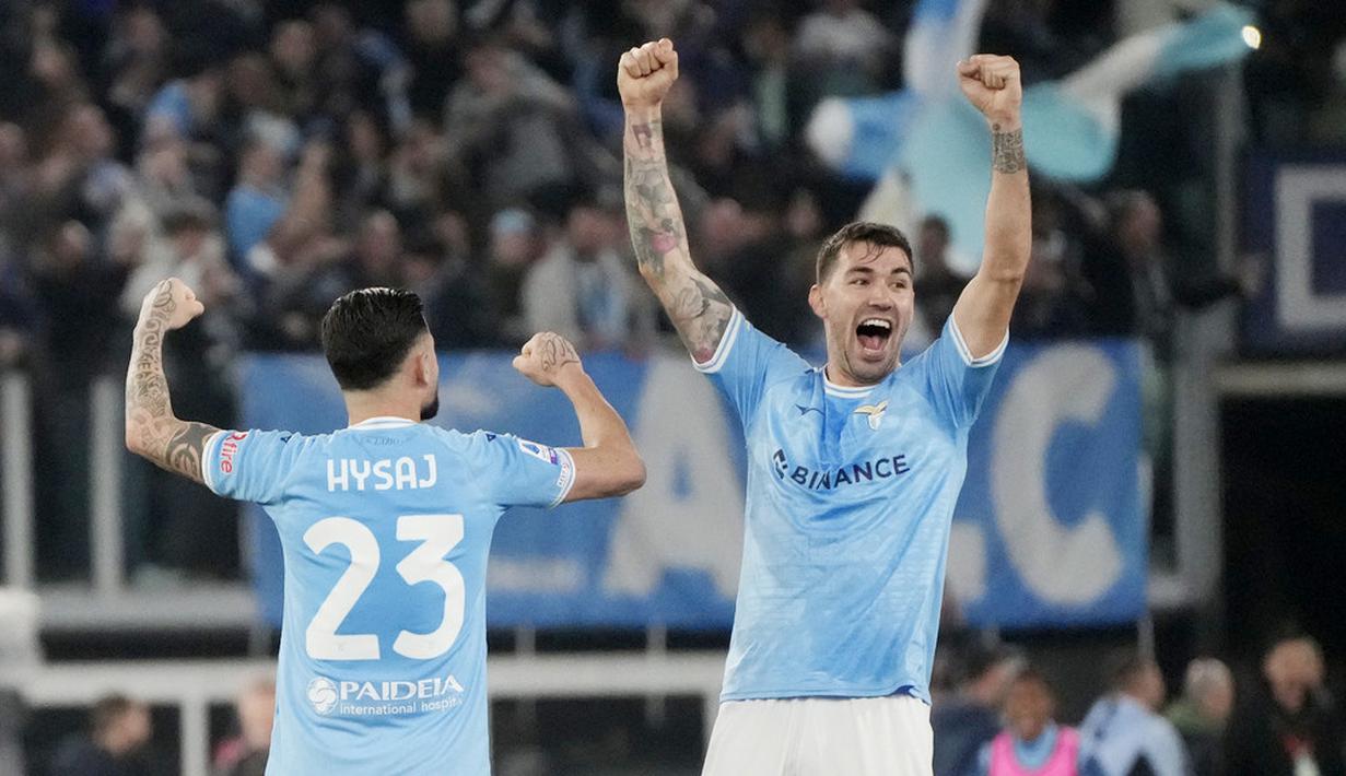 Pemain Lazio, Alessio Romagnoli dan Elseid Hysaj, merayakan kemenangan atas AS Roma pada laga pekan ke-27 Serie A 2022/2023 di Stadion Olimpico, Senin (20/03/2023). Hasil ini membuat Lazio sekarang naik ke peringkat dua klasemen sementara Serie A 2022/2023 dengan koleksi 52 angka dari 27 laga. Sementara Roma tertahan di posisi lima dengan raihan 47 angka. (AP Photo/Gregorio Borgia)