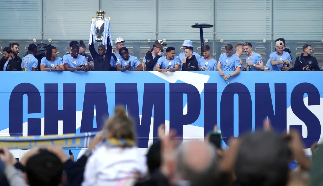 Para pemain Manchester City menyapa para penggemar dari atas bus saat parade kemenangan Liga Inggris di Manchester, Inggris, 23 Mei 2022. (AP Photo/Jon Super)