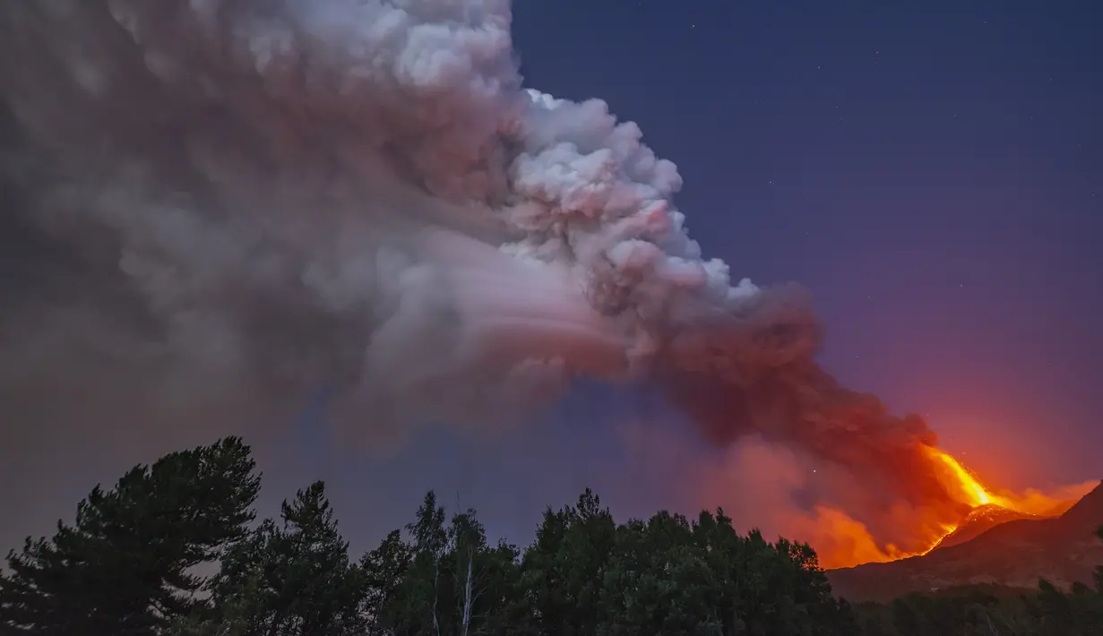 Asap mengepul dari Gunung Etna seperti yang terlihat dari Linguaglossa, Sisilia, Italia, Senin (9/8/2021). Gunung berapi paling aktif di Eropa tersebut menyemburkan abu vulkanik dan lava pijar ke sekitar area berpenduduk padat di lerengnya. (AP Photo/Salvatore Allegra)