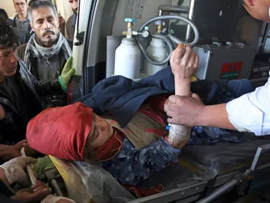 Tim medis dibantu warga memberikan pertolongan kepada wanita korban serangan bom bunuh diri di Kabul, Afghanistan (28/12). Ledakan tersebut menewaskan puluhan orang. Dilaporkan bahwa kebanyakan korban ledakan adalah pelajar. (AP Photo / Rahmat Gul)