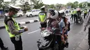 Anggota Polantas memeriksa surat kelengkapan pengendara motor saat Operasi Zebra Jaya di jalan Letjen Suprapto, Jakarta, Selasa (7/11). (Liputan6.com/Faizal Fanani)