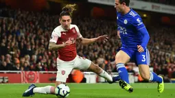 Bek Arsenal, Hector Bellerin, berebut bola dengan bek Leicester, Ben Chilwell, pada laga Premier League Inggris di Stadion Emirates, London, Senin (22/10). Arsenal menang 3-1 atas Leicester. (AFP/Glyn Kirk)