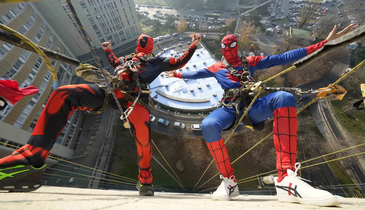 Dua orang berpakaian superhero turun dari atap untuk memberi kejutan di jendela kamar pasien anak di bangsal Pediatri rumah sakit San Paolo di Milan, Italia, Rabu (15/12/2021). Saat beraksi, para superhero memanjat dengan menggunakan tali dibekali alat pengaman yang lengkap. (AP Photo/Luca Bruno)