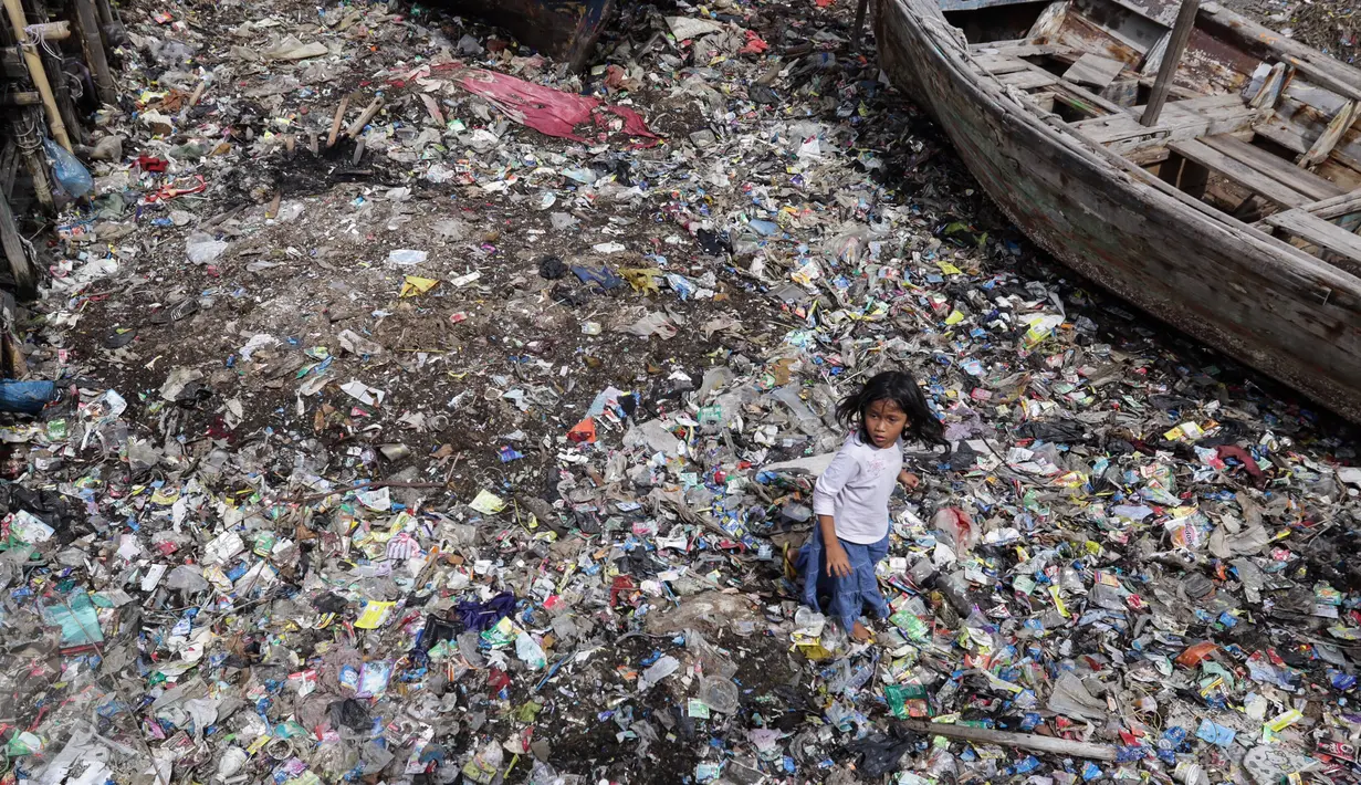 Seorang anak tengah berlari di tumpukan sampah yang mengering di dermaga Tempat Pelelangan Ikan Cilincing, Jakarta Utara, Rabu (8/2). (Fery Pradolo/Liputan6.com)