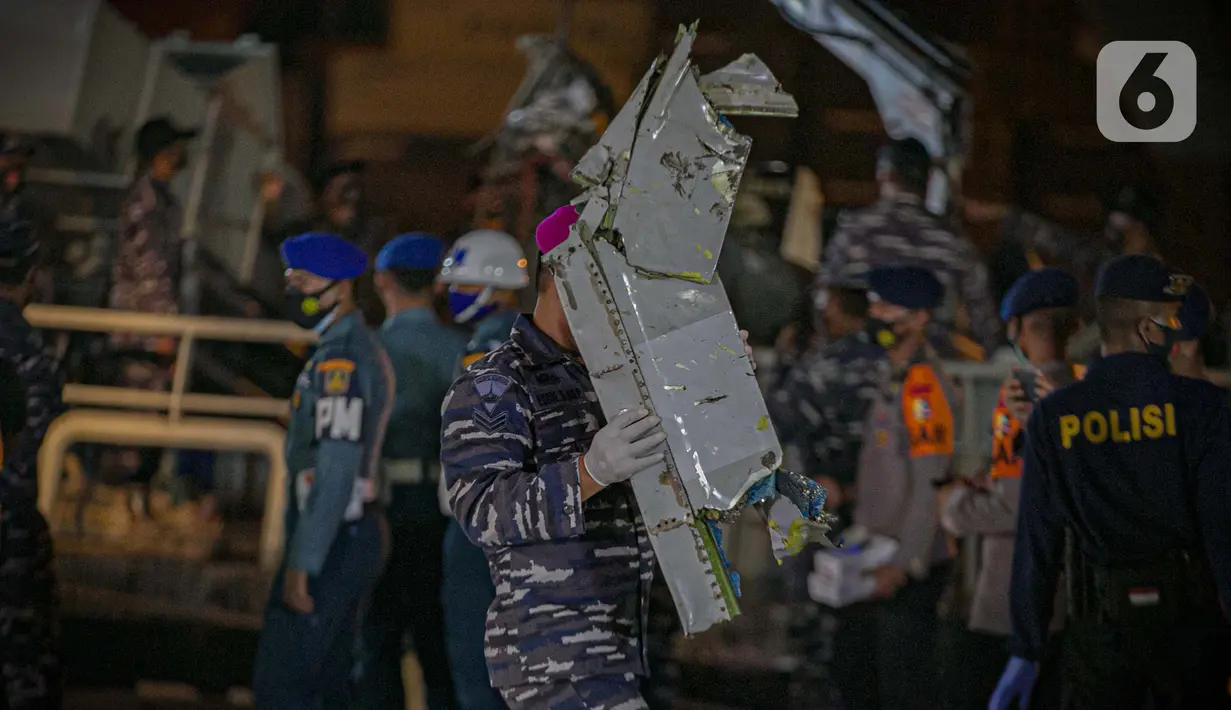 Anggota TNI mengumpulkan puing pesawat Sriwijaya Air nomor penerbangan SJ 182 rute Jakarta-Pontianak pada hari ketujuh operasi SAR pesawat tersebut di JICT II Tanjung Priok, Jakarta Utara, Jumat (15/1/2021). (Liputan6.com/Faizal Fanani)