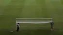 Pekerja mempersiapkan National Stadium untuk turnamen sepak bola Copa America di Brasilia, Brasil, Jumat (11/6/2021). Copa America 2021 akan dibuka dengan laga dari Grup A, antara Brasil vs Venezuela, pada 13 Juni waktu setempat atau 14 Juni dini hari WIB. (AP Photo/Eraldo Peres)