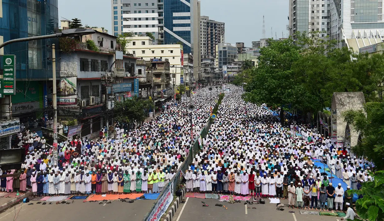 Massa dari kelompok Islam membanjiri jalan di Dhaka, Banglades, Jumat (21/4). Massa menuntut pemerintah untuk menghancurkan sebuah patung di depan Mahkamah Agung karena dianggap sebagai berhala. (AFP PHOTO / STR)