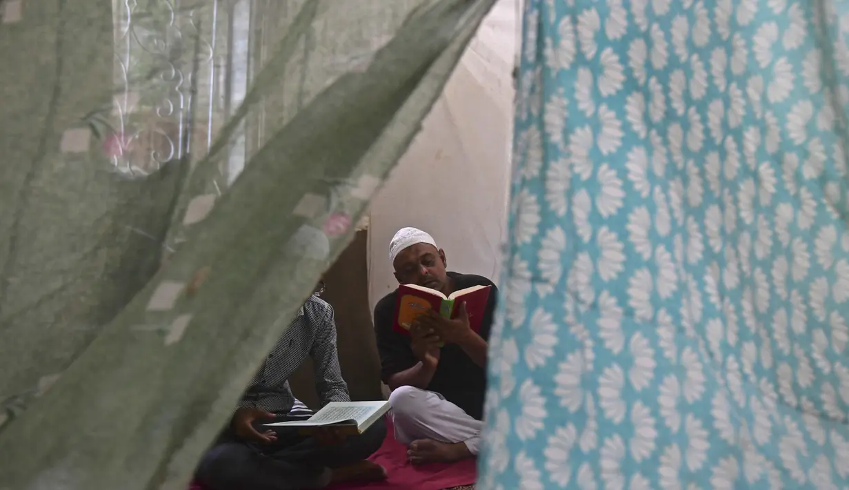 Seorang pria Muslim membaca Alquran di awal Itikaf, di masjid untuk pria selama bulan suci Ramadhan di Karachi (3/5/2021). Umat Muslim melakukan Itikaf 10 hari terakhir bulan Ramadhan, dalam rangka meraih malam kemuliaan atau Lailatul Qadar. (AFP/Asif Hassan)