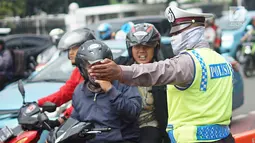 Polisi memberi arahan pada pengendara motor di sekitar lokasi pengalihan arus lalu lintas di Jalan Medan Merdeka Timur, Jakarta, Jumat (14/6/2019). Pengalihan arus dilakukan di sejumlah titik menuju Gedung Mahkamah Konstitusi terkait sidang sengketa Pilpres 2019. (Liputan6.com/Immanuel Antonius)