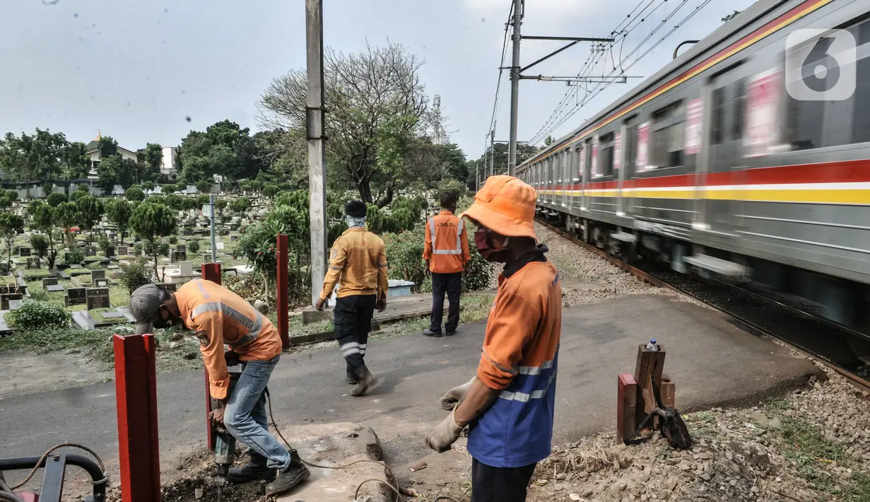 Pekerja PT KAI menyelesaikan pemasangan pembatas jalan di perlintasan kereta tanpa palang pintu di kawasan TPU Tanah Kusir, Jakarta, Kamis (17/9/2020). Pemasangan pembatas jalan dilakukan untuk mencegah kecelakaan kendaraan yang sering terjadi di kawasan tersebut. (merdeka.com/Iqbal S. Nugroho)