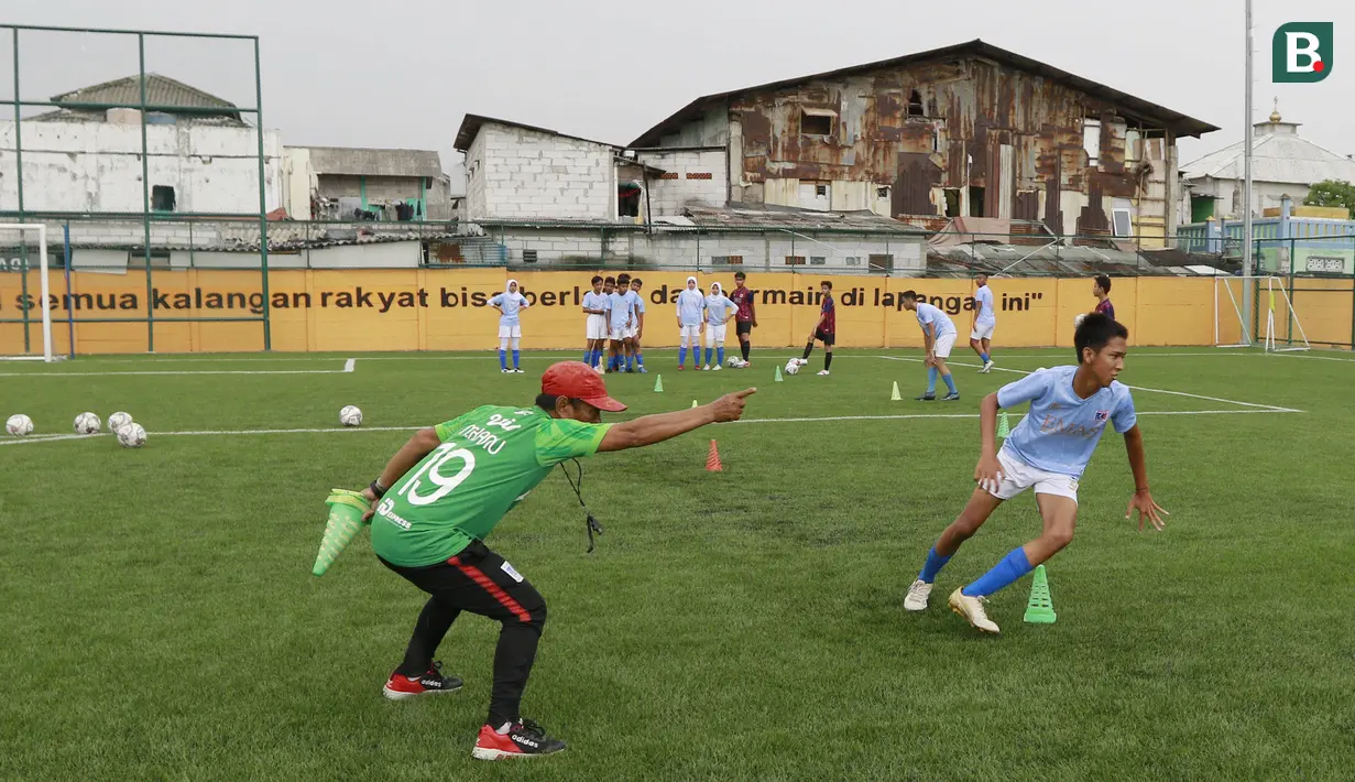 Seorang pelatih memberikan arahan kepada anak asuhnya saat berlatih di Lapangan Ingub Muara Angke, Jakarta Utara. (Bola.com/M Iqbal Ichsan)