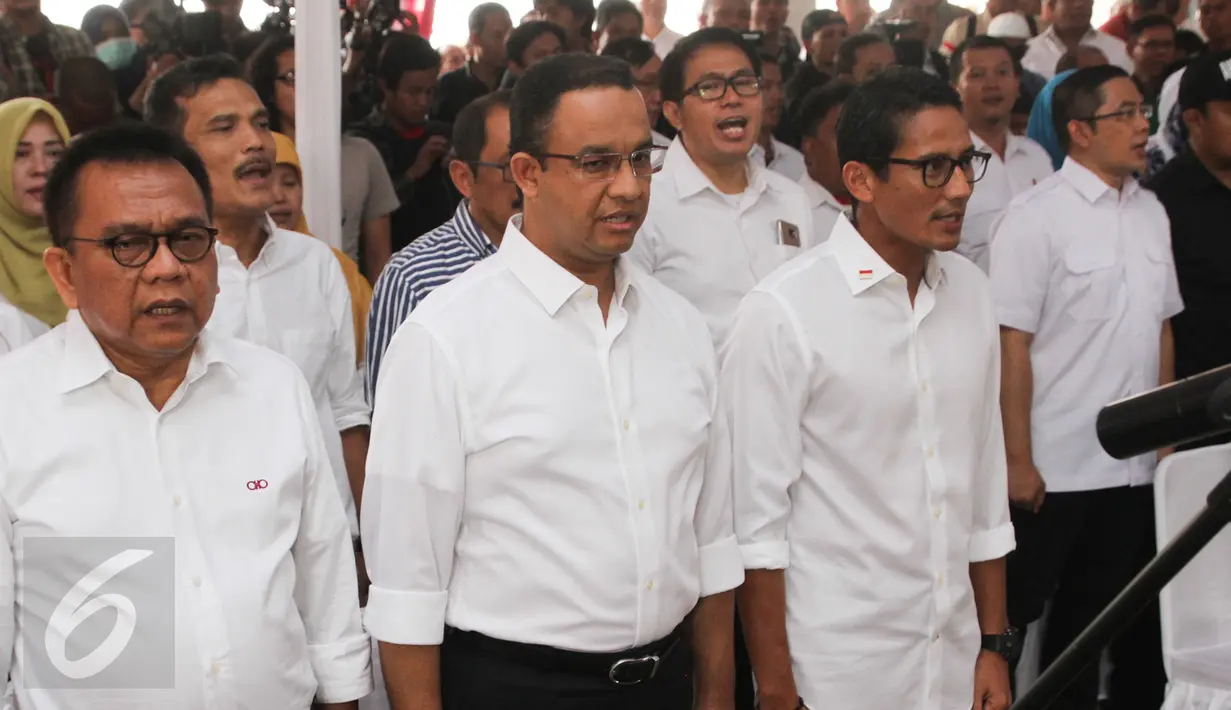 Pasangan cagub dan cawagub DKI, Anies Baswedan dan Sandiaga Uno menyanyikan lagu Indonesia Raya, Jakarta, Kamis (20/10). Cagub dan Cawagub Anies-Sandiaga meluncurkan logo kampanye mereka untuk Pilkada DKI Jakarta 2017. (Liputan6.com/Yoppy Renato)