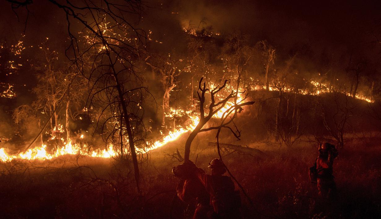 Petugas berusaha memadamkan api yang melanda kawasan California, Amerika Serikat, Sabtu (8/7). CalFire mengatakan terdapat 5 warga dan seorang petugas damkar yang terluka akibat bencana tersebut. (AP Photo / Noah Berger)