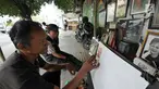 Seorang pelukis melukis di trotoar Kawasan Glodok, Jakarta, Selasa (15/5). Pelukis trotoar yang terhimpun dalam kelompok pelukis Kota ini menjual hasil lukisannya dan juga menawarkan jasa lukis potret. (Liputan6.com/Herman Zakharia)