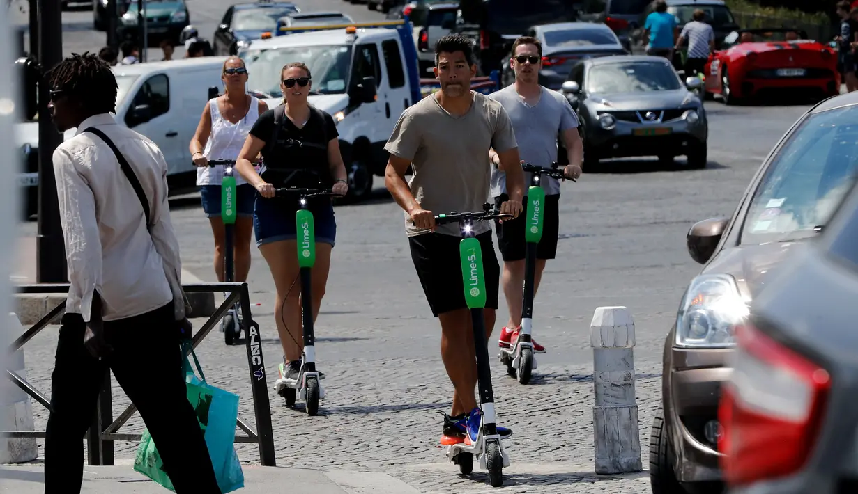 Orang-orang beraktivitas menggunakan skuter listrik di Paris, Prancis (9/7). Skuter listrik ini dibuat oleh perusahaan AS Lime yang merupakan penyewaan transportasi sepeda dan skuter di berbagai kota. (AFP Photo/Francois Guillot)