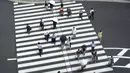 Orang-orang berjalan melintasi persimpangan dekat Stasiun Tokyo di Tokyo sehari setelah kasus virus corona tertinggi ditemukan di kota tuan rumah Olimpiade Kamis (29/7/2021). Tokyo telah melaporkan jumlah tertinggi infeksi Covid-19 hanya beberapa hari setelah dimulainya Olimpiade. (AP/Kntaro Komiya)