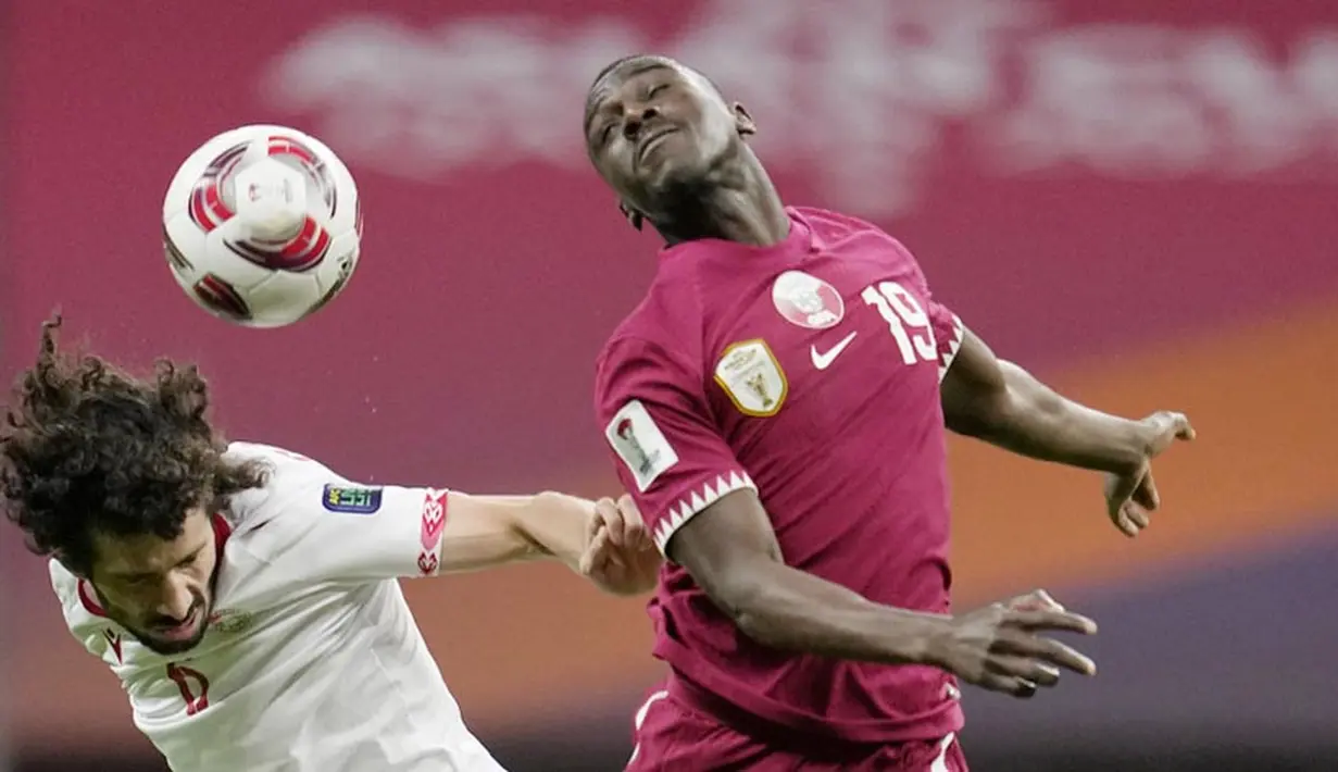 Pemain Qatar, Almoez Ali, duel udara dengan pemain Tajikistan, Vahdat Hanonov, pada laga Grup A Piala Asia di Stadion Al Bayt , Rabu (17/1/2024).  Kemenangan ini sekaligus menjadikan Qatar sebagai tim pertama yang lolos ke babak 16 besar. (AP Photo/Aijaz Rahi)