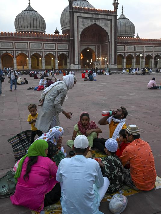 Umat Muslim berbuka puasa di masjid Jama Masjid pada hari pertama bulan suci Ramadhan, di New Delhi (14/4/2021). Masjid ini didirikan oleh Kaisar Mogul, Syah Jehan, yang juga membangun Taj Mahal. (AFP/Prakash Singh)