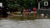 Warga melewati banjir yang menggenangi Jalan Jatinegara Barat, Jakarta, Kamis (2/1/2020). Hujan yang terjadi kemarin malam membuat Kali Ciliwung meluap ke jalan. (merdeka.com/Imam Buhori)