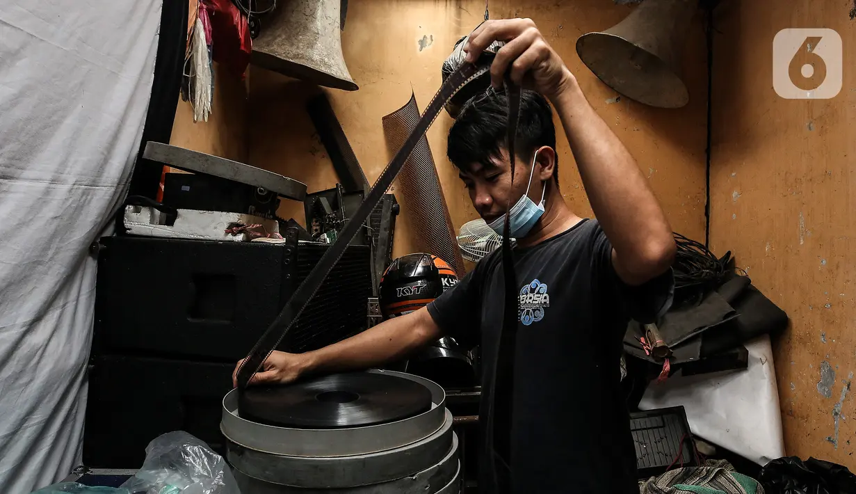 Adul (29) mengecek film seluloid 35mm di gudang rumahnya di Jakarta, Rabu (28/4/2021). Seperti salah satu keluarga yang menyediakan alat dan film seluloid 35mm untuk pergelaran layar tancap, Adul (29) yang melanjutkan usaha orang tua nya sejak puluhan tahun lalu ini. (Liputan6.com/Johan Tallo)