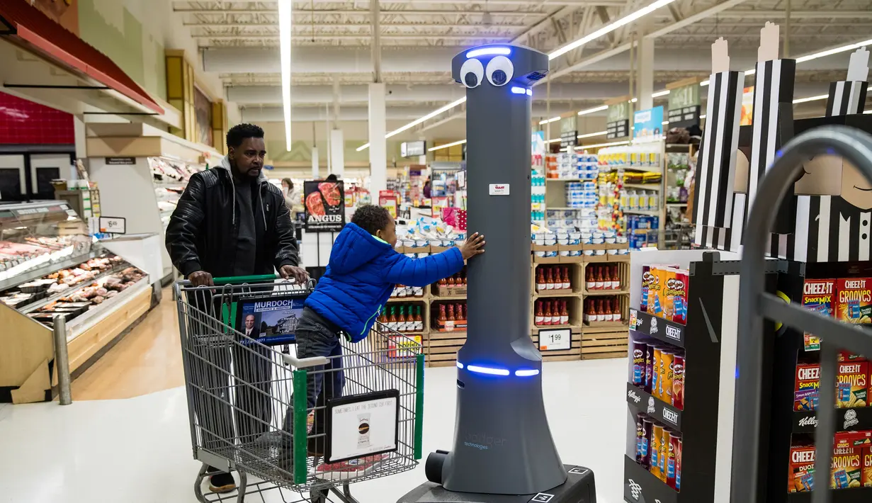 Seorang anak memegang robot bernama Marty yang sedang bekerja di pasar swalayan Giant Food Stores di Harrisburg, Pennsylvania, AS, Selasa (15/1). Robot Marty bertenaga baterai isi ulang dan memiliki beberapa kamera internal. (AP Photo/Matt Rourke)