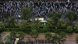 Setelah menunaikan ibadah Salat Jumat di Monas, Jakarta, massa aksi 2 Desember mulai membubarkan diri dengan tertib, Jumat (2/12). Massa yang sudah basah kuyup akibat kehujanan memilih kembali pulang ke rumah masing-masing. (Liputan6.com/Johan Tallo)