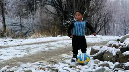 Murtaza Ahmadi, anak laki-laki Afghanistan, bermain bola sambil mengenakan kaos kantong kresek timnas Argentina milik Lionel Messi di  kabupaten Jaghori, provinsi Ghazni, 29 Januari 2016. Sebelumnya, foto Murtaza itu menyebar luas di dunia maya (STR/AFP)