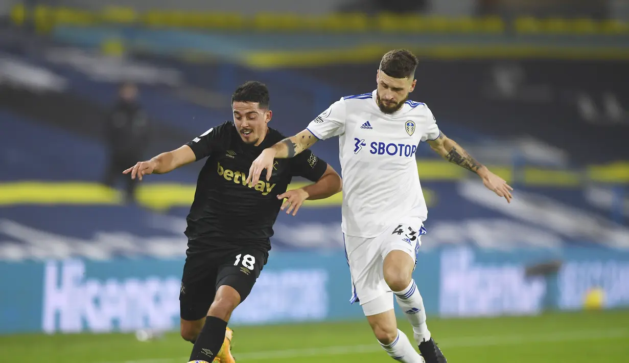 Gelandang West Ham, Pablo Fornals (kiri) membawa bola dari kejaran gelandang Leeds United, Mateusz Klich pada pertandingan lanjutan Liga Inggris di stadion Elland Road di Leeds, Inggris, Sabtu (12/12/2020). West Ham menang tipis atas Leeds United 2-1. (Gareth Copley, Pool via AP)