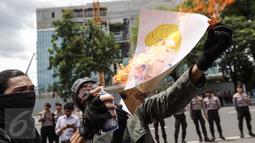 Massa aksi membakar poster Presiden AS Donald Trump saat unjuk rasa di depan kantor Kedubes AS di Jakarta Sabtu (4/2). Munculnya kebijakan Trump dianggap merugikan sebagian warga. (Liputan6.com/Fery Pradolo)