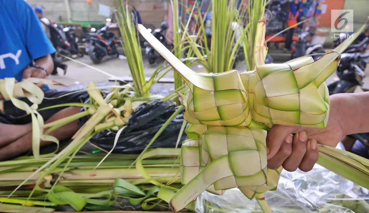 Pedagang menunjukkan satu ikat kulit ketupat siap jual di Pasar Kemiri Muka, Depok, Jawa Barat, Selasa (12/6). Menjelang Lebaran, pedagang kulit ketupat mengaku kebanjiran pembeli. (Liputan6.com/Herman Zakharia)