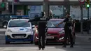 Petugas polisi setempat mengontrol pergerakan orang di sebuah pos pemeriksaan lalu lintas di kota Fuenlabrada yang tertutup sebagian, di wilayah Madrid (22/9/2020). Pemerintah daerah Madrid telah memberlakukan penguncian sebagian di beberapa daerah berpenduduk padat. (AFP/Oscar Del Pozo)
