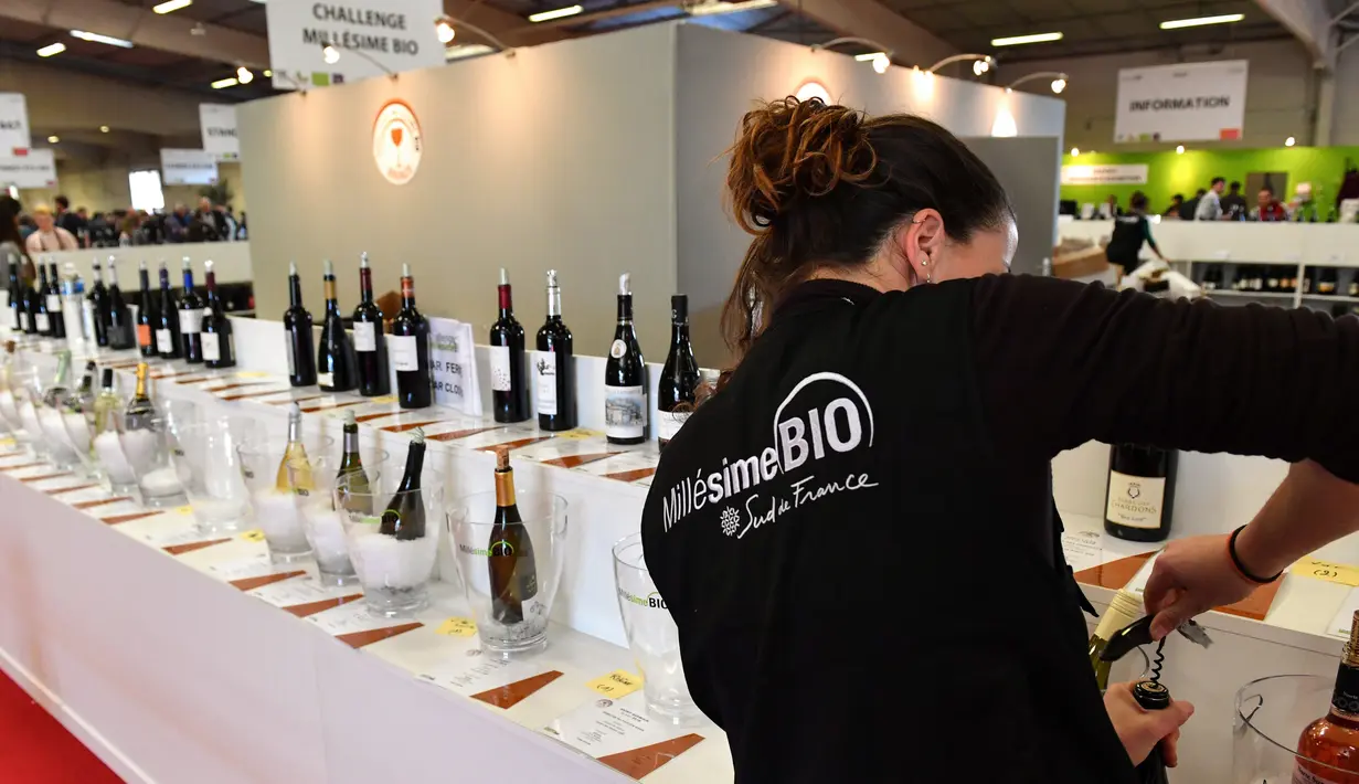 Pengunjung membuka botol wine organik dalam acara Millesime Bio 2018 di Kota Montpellier, Prancis, Senin (29/1). (AFP PHOTO/PASCAL GUYOT)