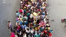 Pekerja migran dan anggota keluarga mereka menyerbu terminal bus Anand Vihar untuk pulang kampung selama pemberlakukan lockdown di New Delhi, Sabtu (28/3/2020). Ribuan orang meninggalkan New Delhi setelah pemerintah India memberlakukan lockdown untuk mencegah penyebaran COVID-19. (Bhuvan BAGGA/AFP)