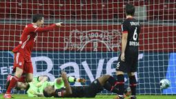 Striker Bayern Munchen, Robert Lewandowski, mencetak gol ke gawang Bayer Leverkusen pada laga Bundesliga di Stadion BayArena, Minggu (20/12/2020). Bayern Munchen menang dengan skor 2-1. (Bernd Thissen/Pool Photo via AP)
