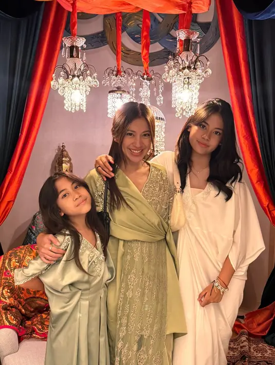 Tyna Dwi Jayanti bersama kedua putrinya kompak kenakan baju shimmer model kaftan di hari Lebaran. Meski serupa, ketiganya pilih warna outfit yang berbeda. [@tynadwijayanti]