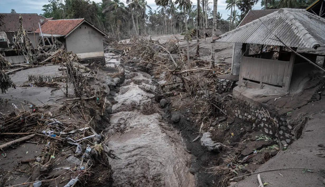 Rumah-rumah rusak akibat erupsi Gunung Semeru terlihat di Desa Sumber Wuluh, Lumajang, Jawa Timur, Senin (6/12/2021). Desa Sumber Wuluh luluh lantak diterjang erupsi Semeru mengakibatkan puluhan rumah rusak dan ratusan warga mengungsi. (Juni Kriswanto/AFP)