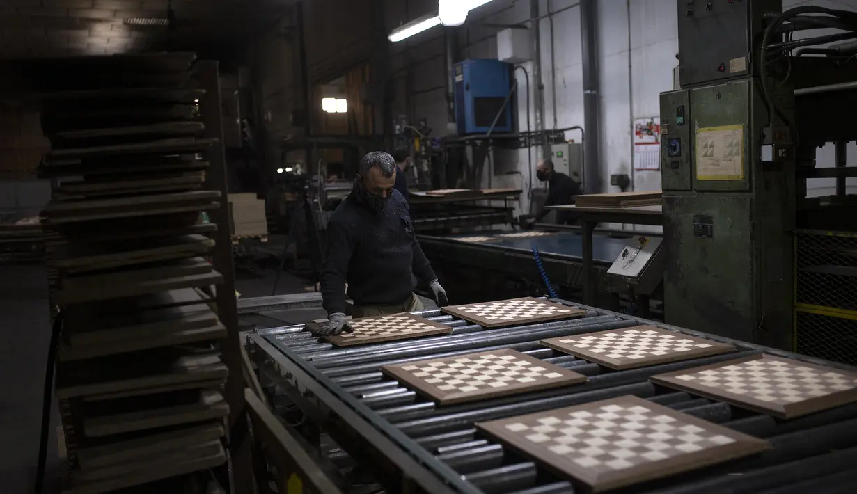 Karyawan Rechapados Ferrer membuat papan catur di La Garriga dekat Barcelona (5/3/2021). Penjualan pembuat papan catur Spanyol itu melonjak sejak ditampilkan di serial Netflix terkenal "The Queen's Gambit". (AFP Photo/Josep Lago)