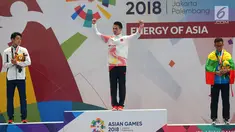Atlet wushu putra China, Chen Zhouli (tengah) menunjukkan medali emas Asian Games 2018 di JIExpo, Kemayoran, Jakarta, Rabu (22/8). Chen Zhouli berhasil merebut medali emas pada nomor Taijiquan dan Taijijian. (Merdeka.com/Imam Buhori)