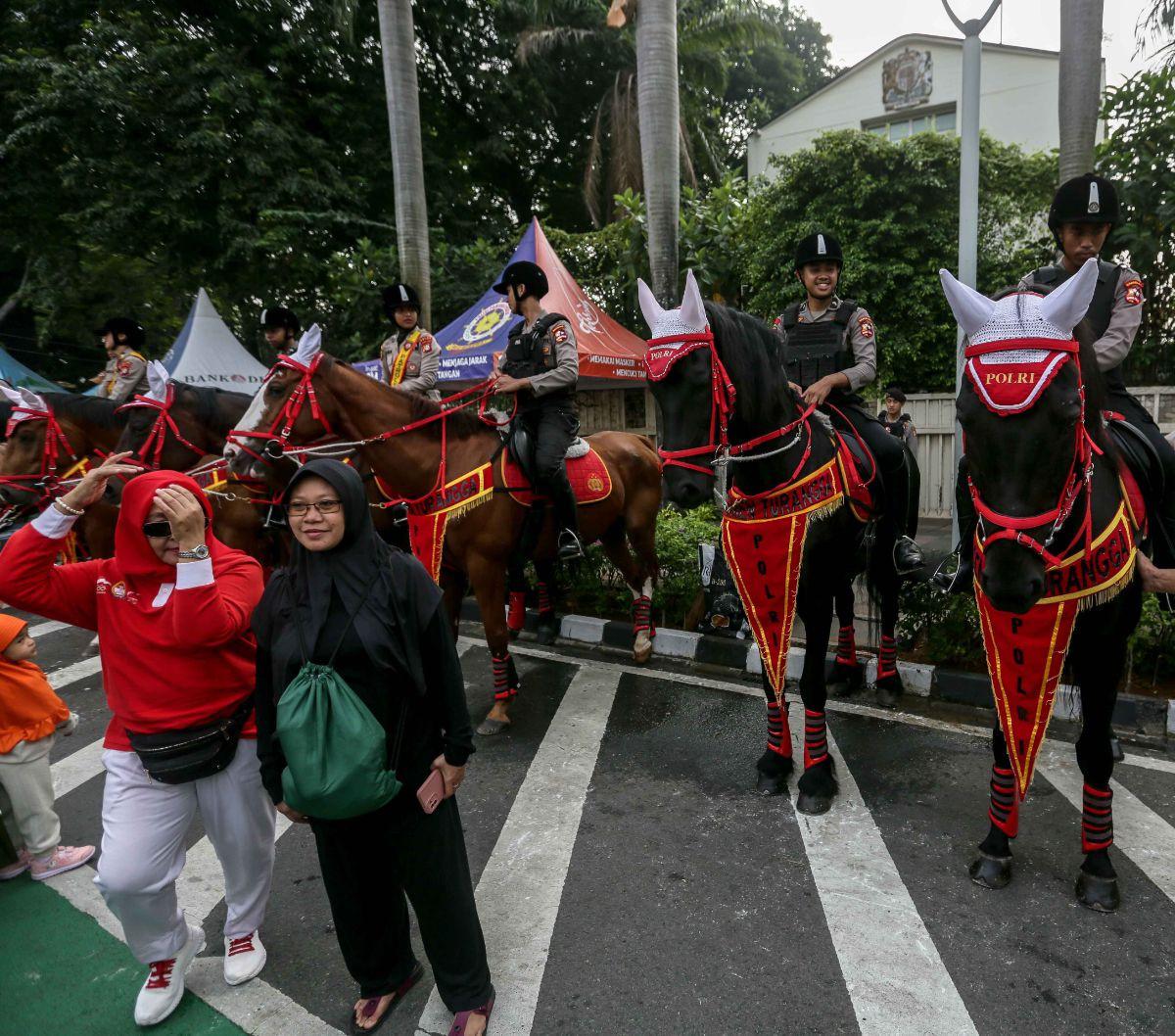Tak hanya anak-anak, orang dewasa pun tak mau melewatkan kesempatan ini. Mereka juga berfoto di depan pasukan Polisi Berkuda dari Detasemen Turangga Direktorat Polisi Satwa Polri.