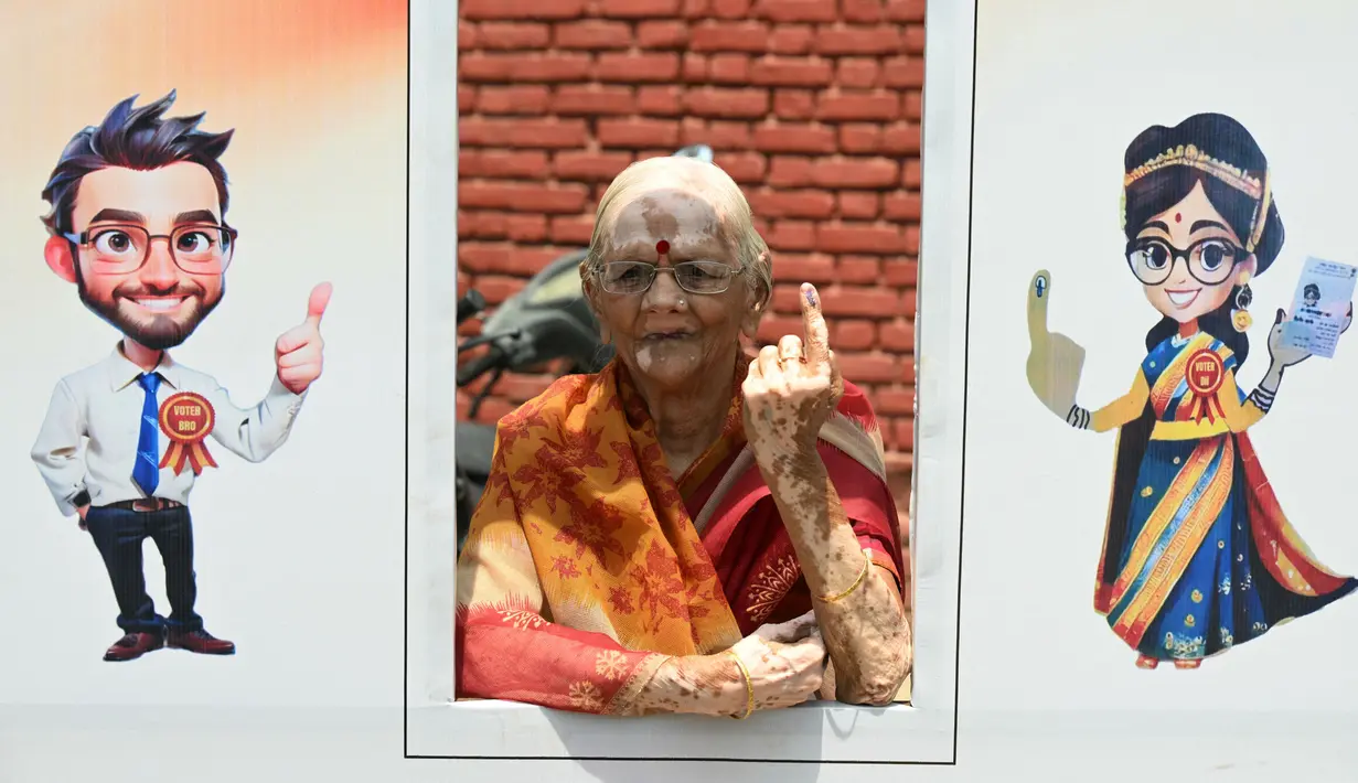 Seorang pemilih menunjukkan jarinya yang bertinta setelah memberikan suaranya dalam pemungutan suara tahap kedua pada pemilihan umum India di Ghaziabad pada 26 April 2024. (Sajjad HUSSAIN/AFP)