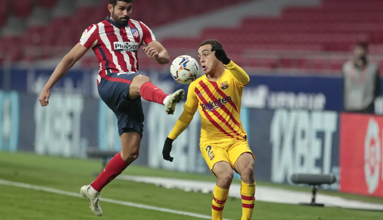 Penyerang Atletico Madrid, Diego Costa berebut bola dengan bek Barcelona, Sergino Dest pada pertandingan lanjutan La Liga Spanyol di stadion Wanda Metropolitano di Madrid, Spanyol, Sabtu (21/11/2020). Atletico menang tipis atas Barcelona 1-0. (AP Photo/Bernat Armangue)