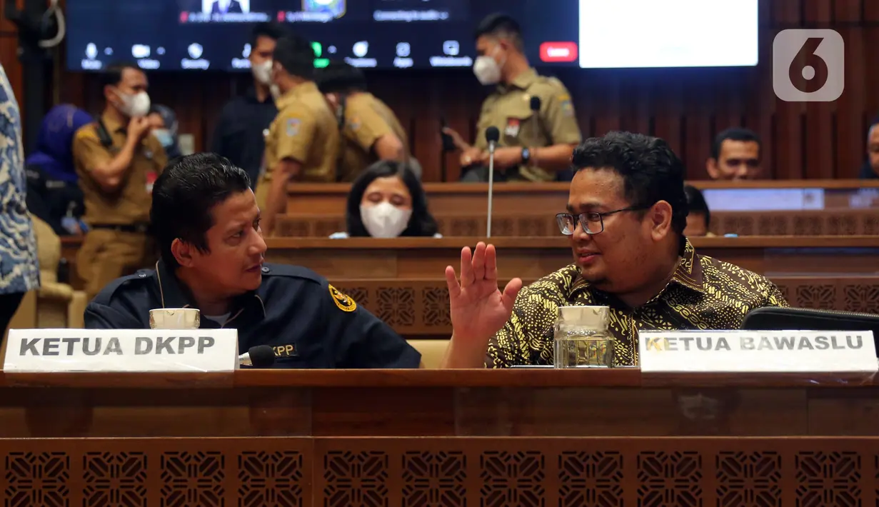 Ketua Bawaslu Rahmat Bagja (kanan) berbincang dengan Ketua DKPP Muhammad (kiri) saat rapat kerja bersama Komisi II DPR RI di Kompleks Parlemen, Senayan, Jakarta, Selasa (7/6/2022). Rapat membahas Peraturan KPU (PKPU) tentang Tahapan dan Jadwal Pemilu 2024. (Liputa6.com/Angga Yuniar)