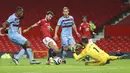 Gelandang Manchester United, Bruno Fernandes, berebut bola dengan kiper West Ham United, Lukasz Fabianski, pada laga Liga Inggris di Stadion Old Trafford, Minggu (15/3/2021). Setan Merah menang dengan skor 1-0. (AP/Clive Brunskill,Pool)