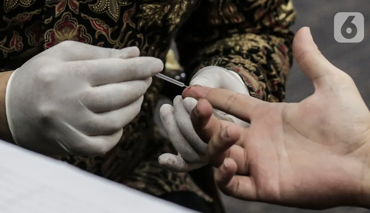 Petugas medis mengambil sampel darah wartawan yang bertugas di DPR saat rapid test di Ruang Wartawan, Kompleks Parlemen, Senayan, Jakarta, Rabu (1/7/2020). Rapid test yang digelar secara gratis ini untuk mendeteksi penyebaran dan memutus mata rantai Penyebaran Covid 19. (Liputan6.com/Johan Tallo)