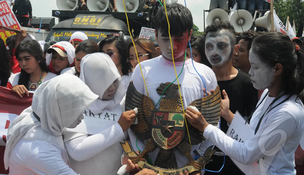 Seorang Demonstran membawa lambang burung Garuda saat aksi teatrikal di depan Istana Merdeka, Jakarta, Senin (16/2/2015). Aksi teatrikal untuk mendesak Presiden Jokowi untuk melantik Budi Gunawan sebagai kapolri. (Liputan6.com/Herman Zakharia).