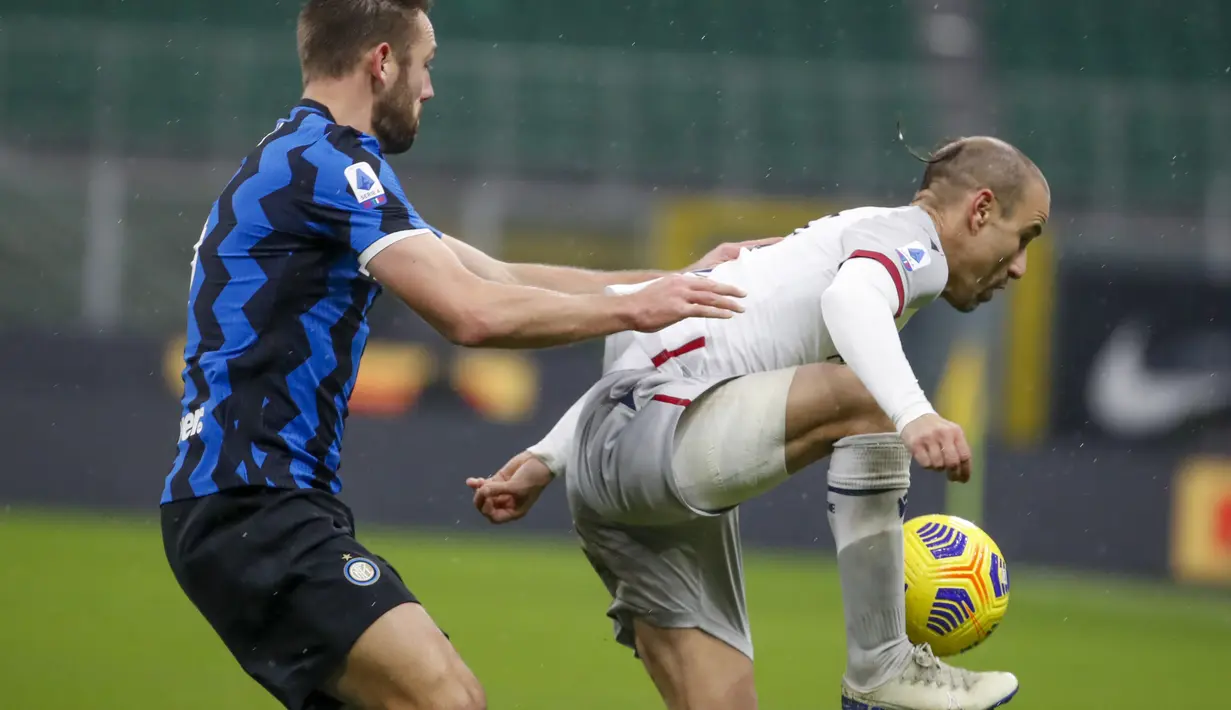 Penyerang Inter Milan, Rodrigo Palacio mengontrol bola dari kawalan bek Inter Milan, Stefan de Vrij (tengah) pada pertandingan lanjutan Liga Serie A Italia di Stadion San Siro Milan, Minggu (6/12/2020). Inter menang 3-1 atas Bologna. (AP Photo/Antonio Calanni)
