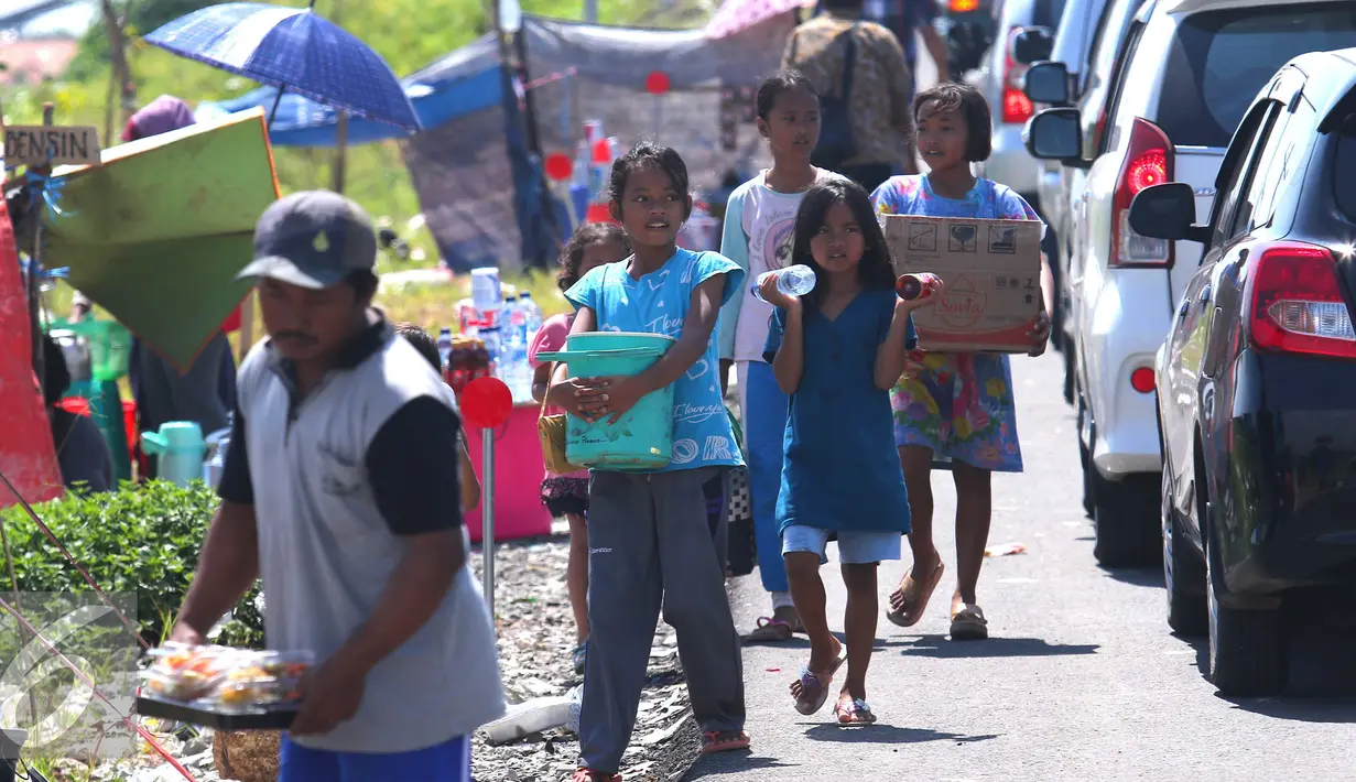 Sejumlah anak berjualan di pintu tol keluar Brebes Timur, Jawa Tengah, (3/7).Mudik lebaran dan libur sekolah di manfaatkan oleh anak-anak yang tinggal di kawasan tersebut untuk berjualan minuman dan makanan. (Liputan6.com/Angga Yuniar)