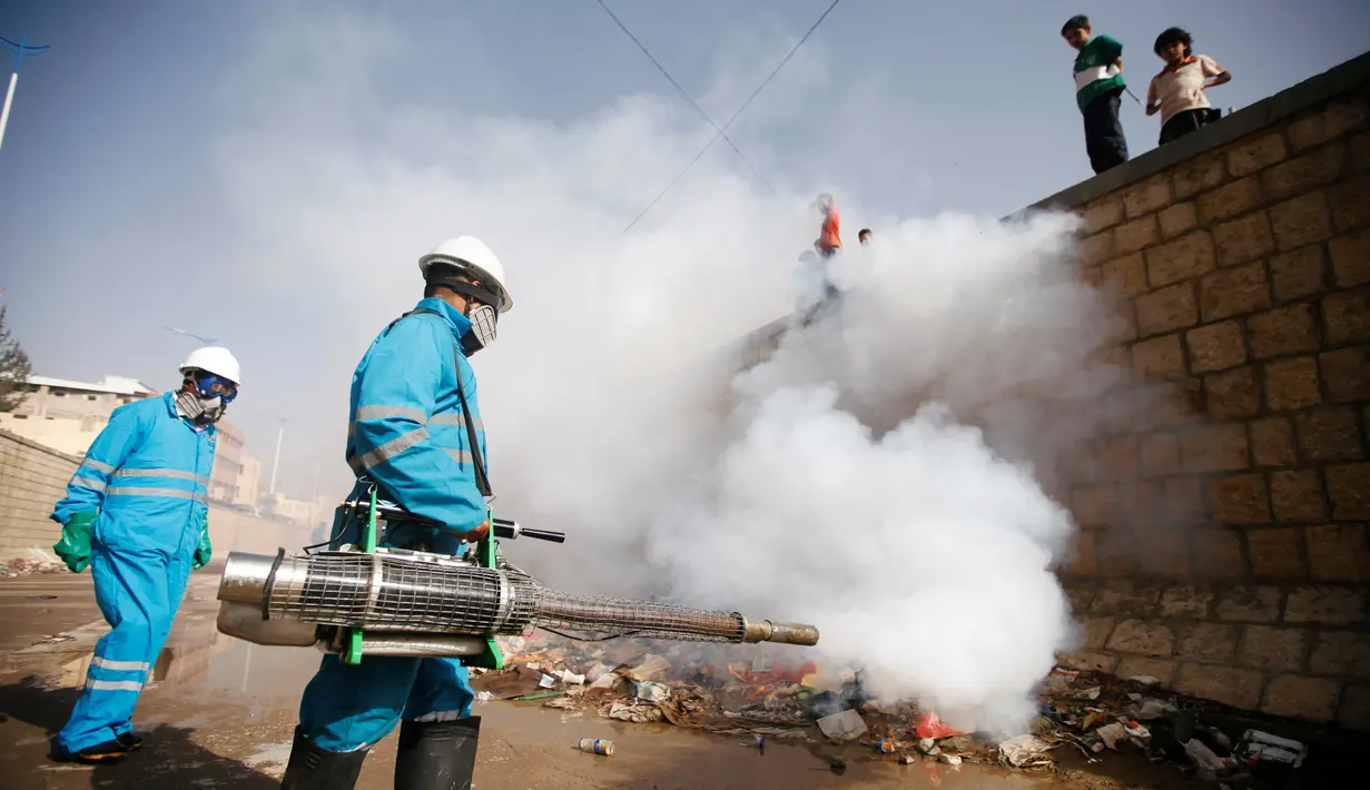 Pekerja menyemprotkan pestisida untuk membasmi wabah kolera di kawasan Sanaa. Yaman menderita wabah dari infeksi yang ditularkan melalui air sejak konflik pecah pada 2015, menyebabkan krisis kemanusiaan paling mendesak di dunia. (REUTERS/Mohamed al-Sayaghi)